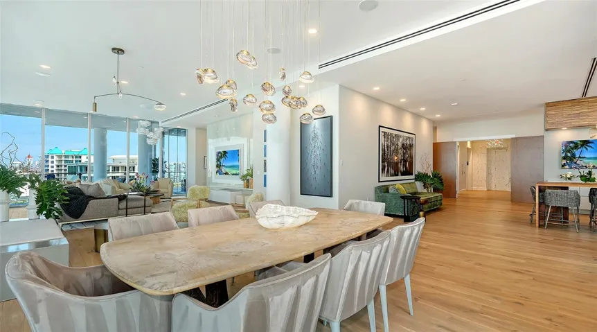 The dining area is highlighted by an Ochre™ hand blown glass chandelier, adding another layer sophistication.
