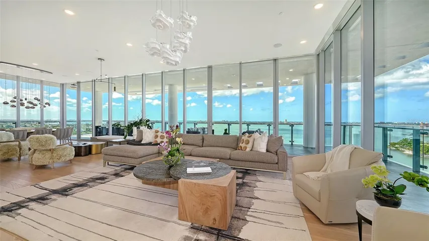 Custom made 11.5 foot floor-to-ceiling impact sliders frame a breathtaking waterfront &amp; cityscape, creating a seamless connection between indoor sophistication and outdoor beauty.