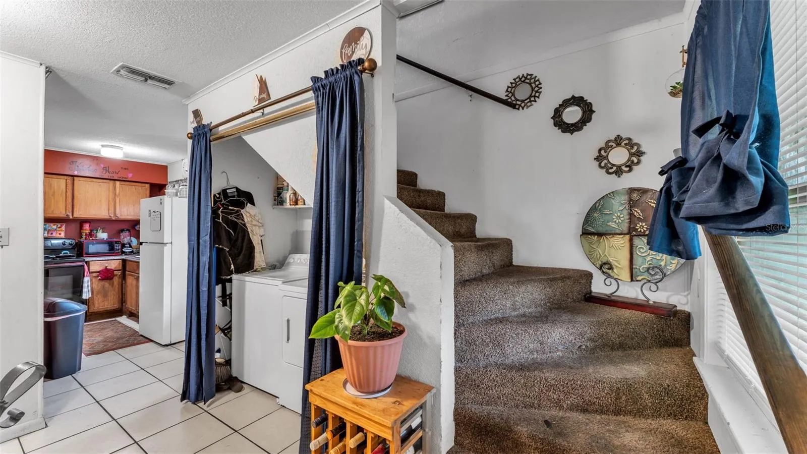Kitchen, laundry closet, stairs that lead up to the second bedroom, bathroom, and bonus area in A-frame loft