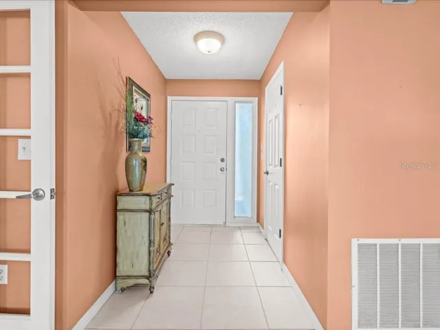 FOYER WITH CERAMIC TILE FLOORS AND A COAT CLOSET
