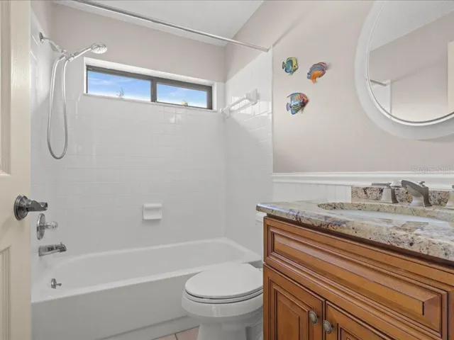 THE MAIN BATHROOM FEATURES UPDATED LIGHTING, VANITY/MIRROW AND GRANITE COUNTER
