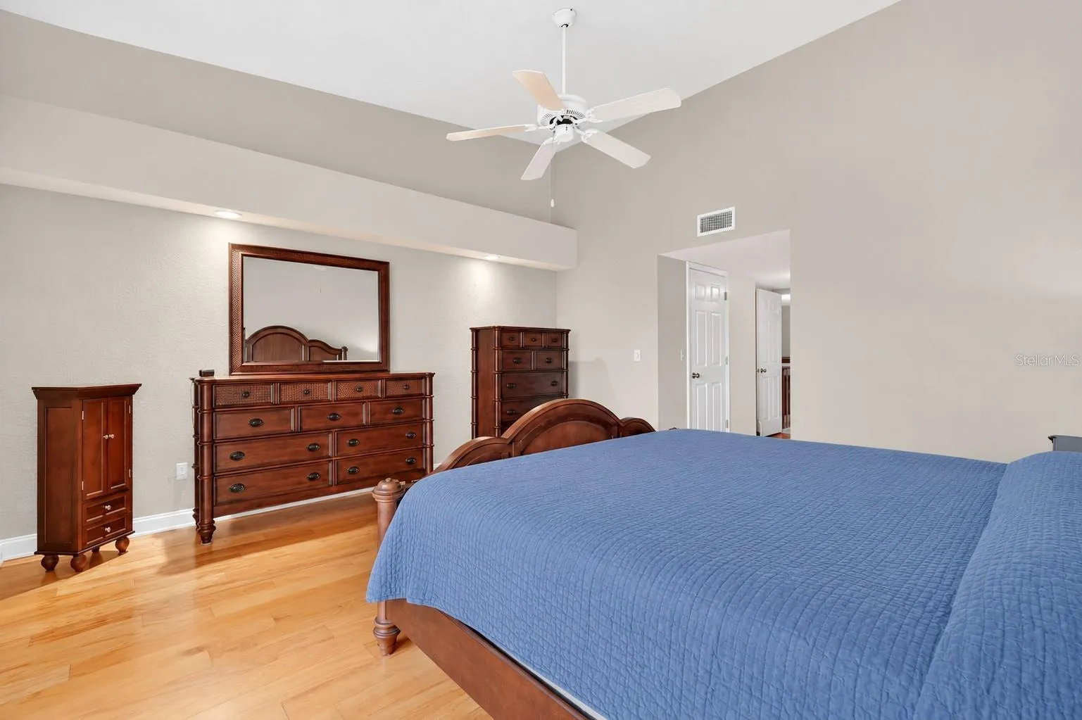 Primary suite with vaulted ceilings and hardwood floors, nature views.