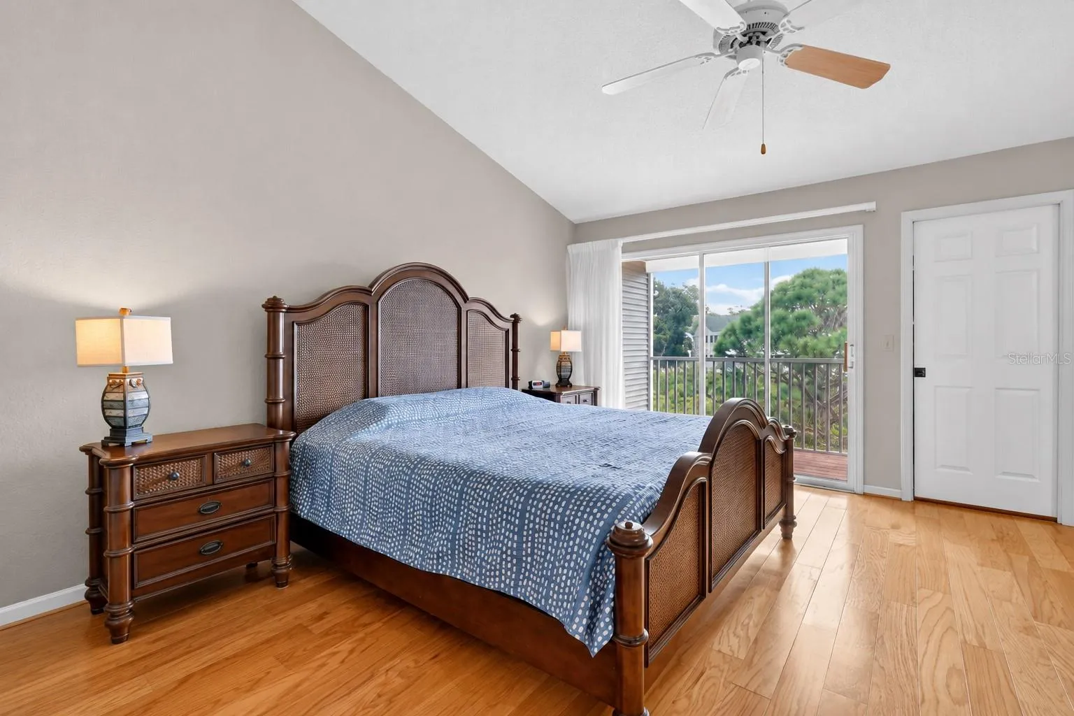Primary bedroom with vaulted ceilings and nature views