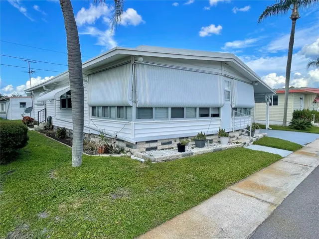 Front… awnings are closed as seller is away. But when opened the home is very light and bright. There is a side entrance to the Primary bedroom, seller does not use it. Side walks around the whole community