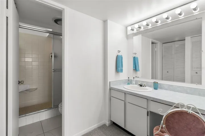 THE PRIMARY ENSUITE BATHROOM FEATURES A TILED SHOWER AND COMMODE.