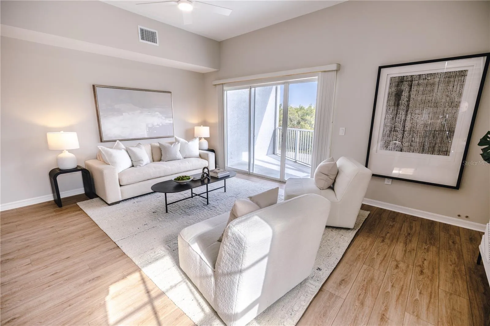 Open concept living and dining room with natural light and balcony overlooking mangroves.