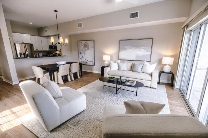 Open concept living and dining room with natural light and balcony overlooking mangroves.
