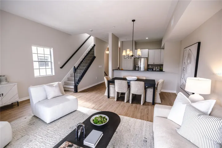 Open concept living and dining room with natural light and balcony overlooking mangroves.
