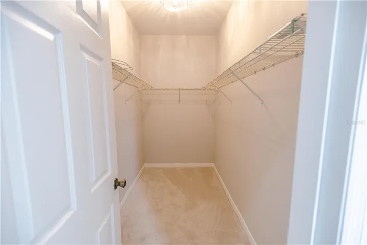 Spacious primary walk-in closet offering plenty of room for organization.