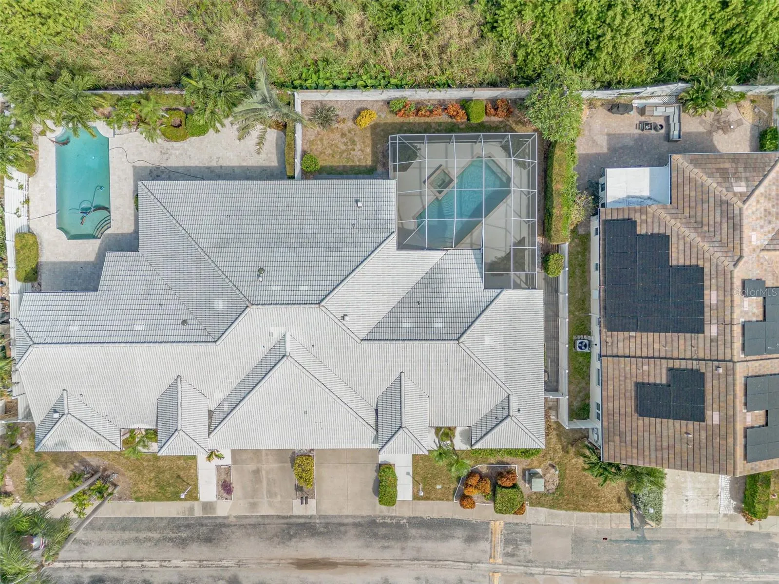 Aerial bird's-eye view of property showing the private screened-in pool cage and spacious backyard layout.