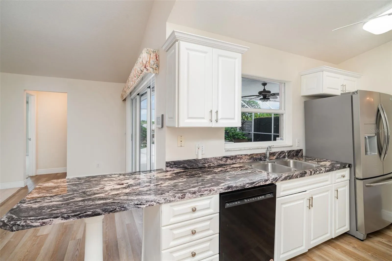 Close-up of the gourmet kitchen showing the large breakfast bar and view into the main living area.