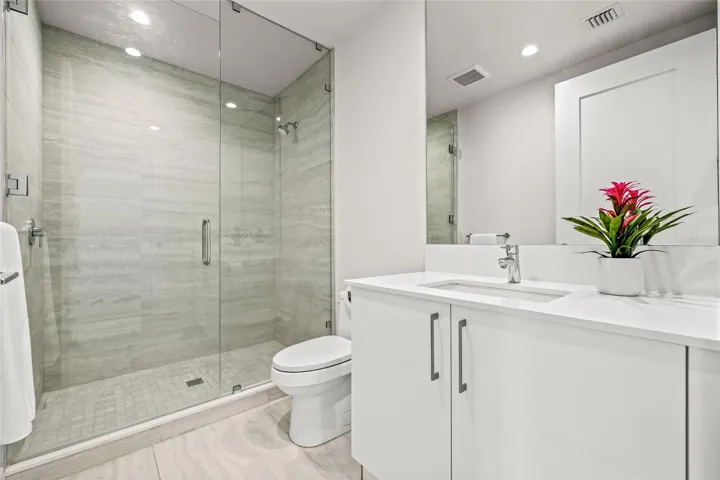 The en suite bath for Bedroom #3 includes a sleek walk-in shower