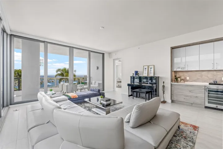Expansive floor-to-ceiling sliders / windows fill the home with natural light, with the primary bedroom just to the right.