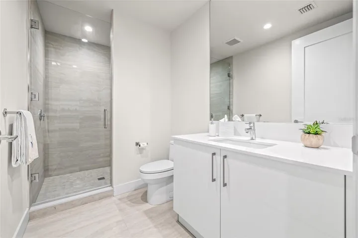 The hall bathroom, conveniently located and offers a spacious vanity with ample counter space and a walk-in shower—perfect for guests.