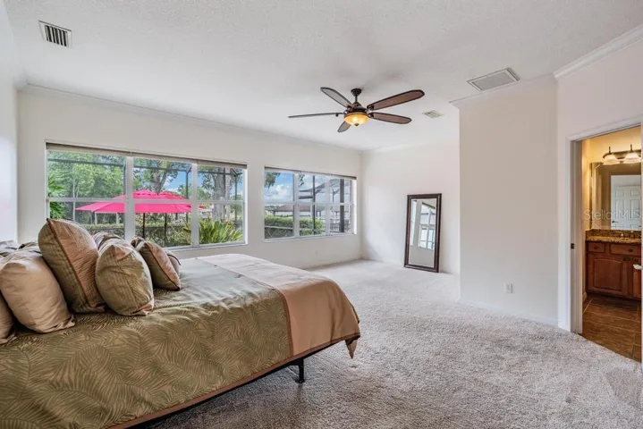 Primary with wall of windows and views of pool and lake