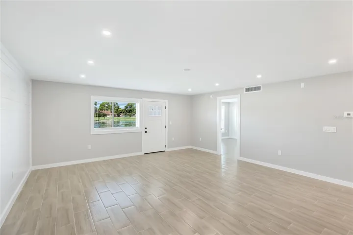 Living room. Exterior door leading out to the back lanai, Primary bedroom to the right
