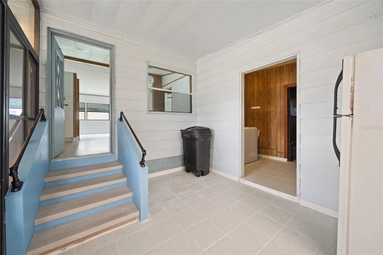 Tiled Hallway Between The Carport &amp; Laundry Room With A Staircase To The Kitchen