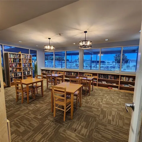 Clubhouse game room and library with views of the pool