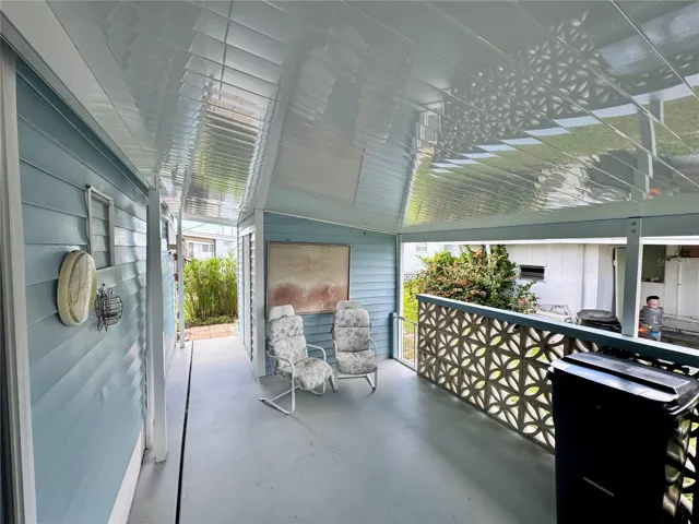 Carport with freshly painted drive and cement privacy fence