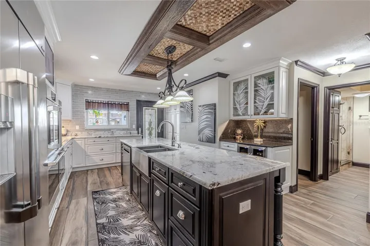 The open dining area creates a warm connection between the kitchen and living spaces, framed by water views and crown-molded ceilings.