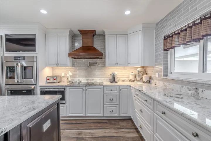 Elegant craftsmanship defines this kitchen, featuring a full brick-style backsplash, soft-close cabinetry, and polished granite counters.