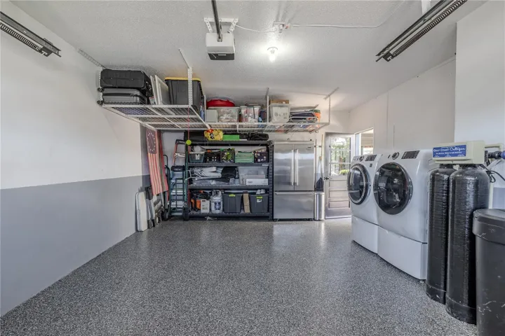 The garage includes a new 2025 washer, 2021 dryer, organized shelving, and plenty of workspace for storage or hobbies.