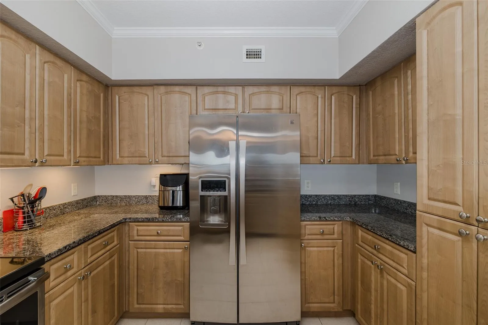 Kitchen with granite countertops, stainless steel appliances, ample cabinetry, and generous workspace.