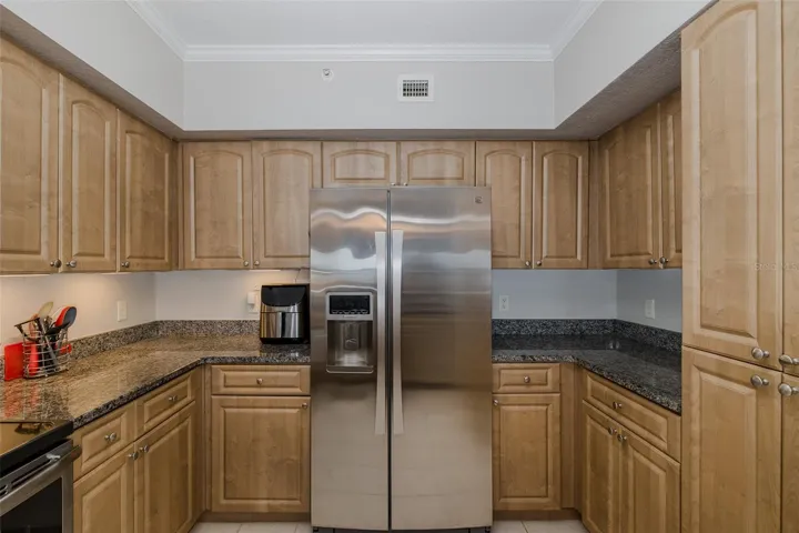 Kitchen with granite countertops, stainless steel appliances, ample cabinetry, and generous workspace.