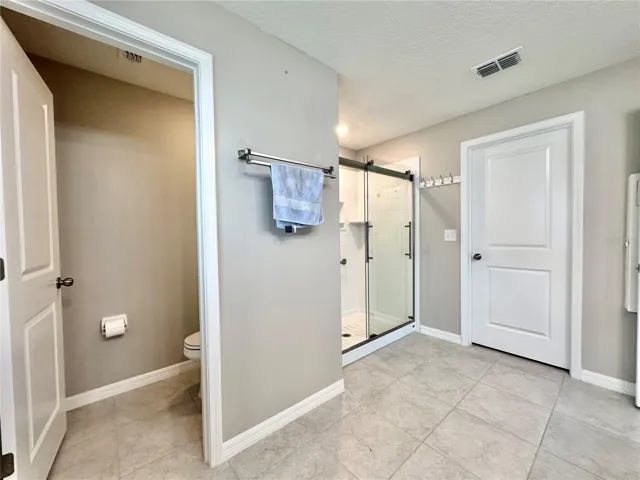 Modern primary bath featuring dual sinks, step-in shower, and bright natural light — elegant and easy to maintain.
