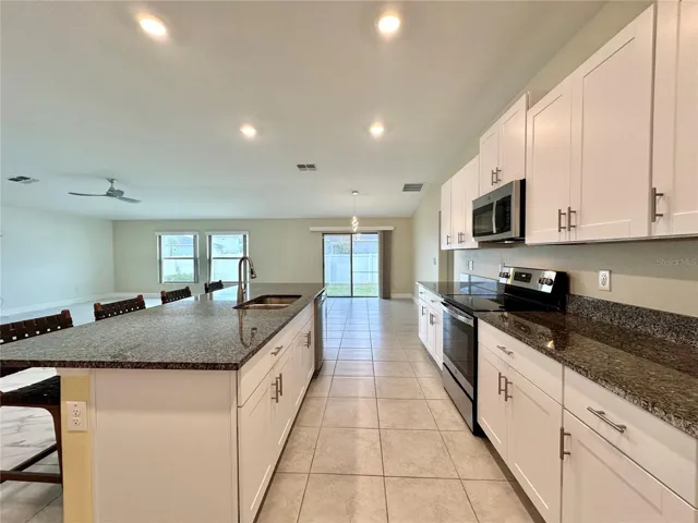 Stylish modern kitchen with solid-surface countertops, stainless steel appliances, and ample storage — perfect for cooking and entertaining.