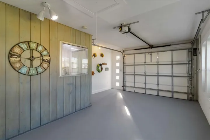 Very clean garage with wood feature wall and impact windows.