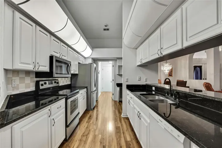 Remodeled kitchen has custom cabinets - granite countertops and backsplash that matches the countertops in the bathrooms.  Kitchen has bright diffused lighting, stainless steel appliances, new dish washer and lovely wood flooring that runs throughout the home.