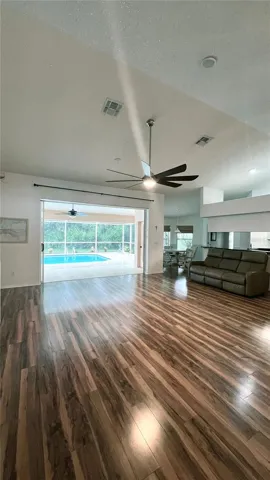 Great room has vaulted ceiling and ceiling speakers for entertainment center which also plays music in the pool area lanai.