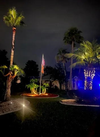 Right side of house at night has lovely accent lighting and a lighted flag you never have to take down.