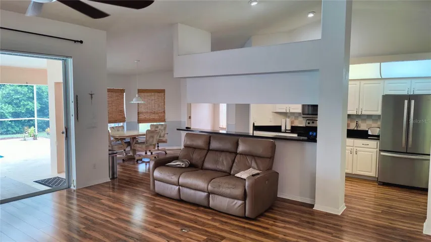 Great room breakfast bar.  Notice electrical outlet in the floor which can be used for power recliners and end table lamps.  Sliding patio doors open up completely if desired for parties or open up to get fresh air breezes on cool days and nights. Spacious high ceilings has recessed lighting in kitchen