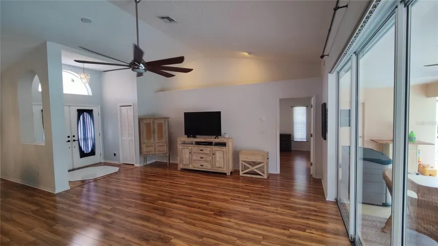 Great room looking at the primary bedroom through the door on the right has gorgeous woof flooring which continues into bedrooms.  Split bedroom plan for your privacy and comfort.