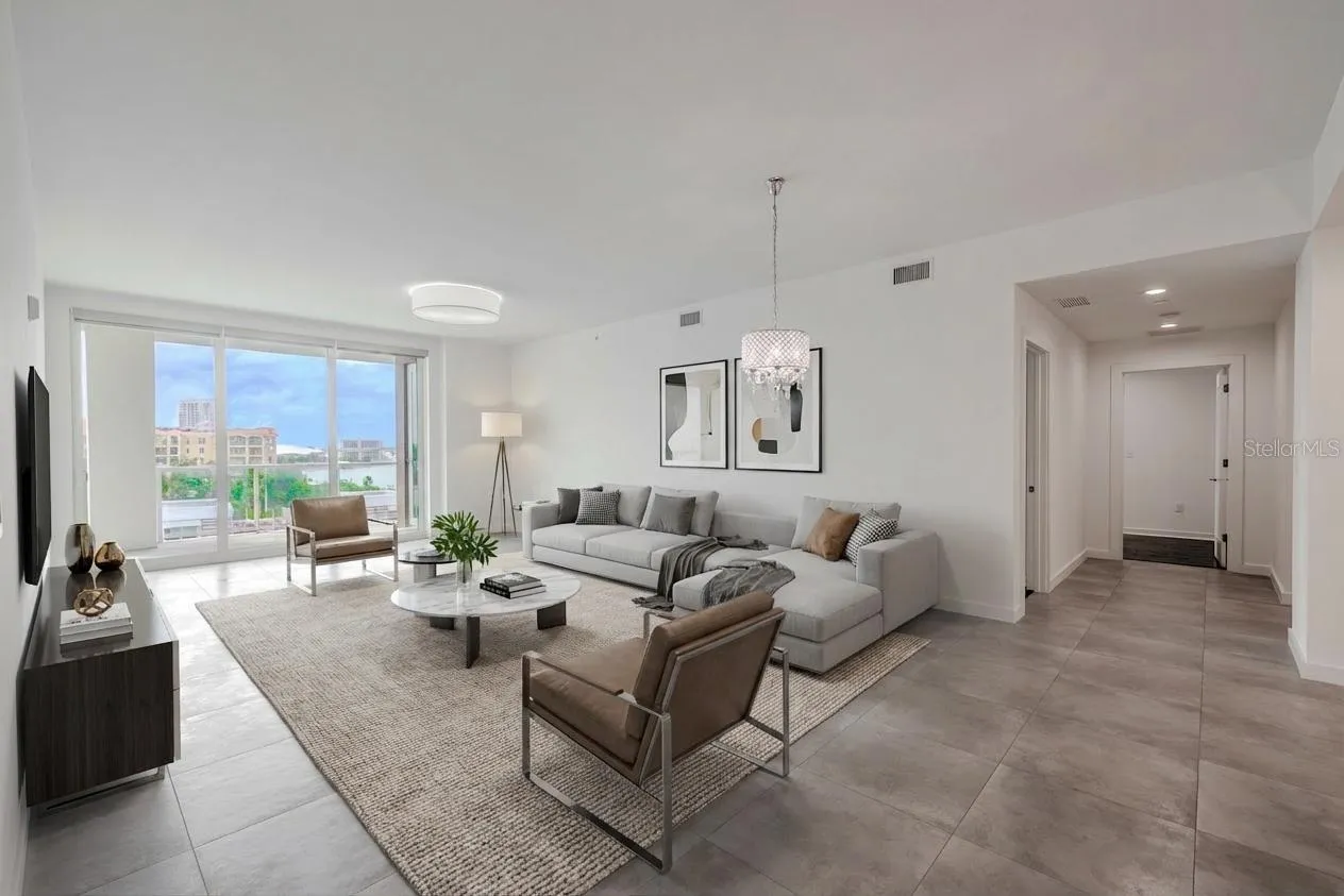 The dining/living room framed by floor to ceiling 'hurricane impact sliders' and a view of the entrance to the primary suite