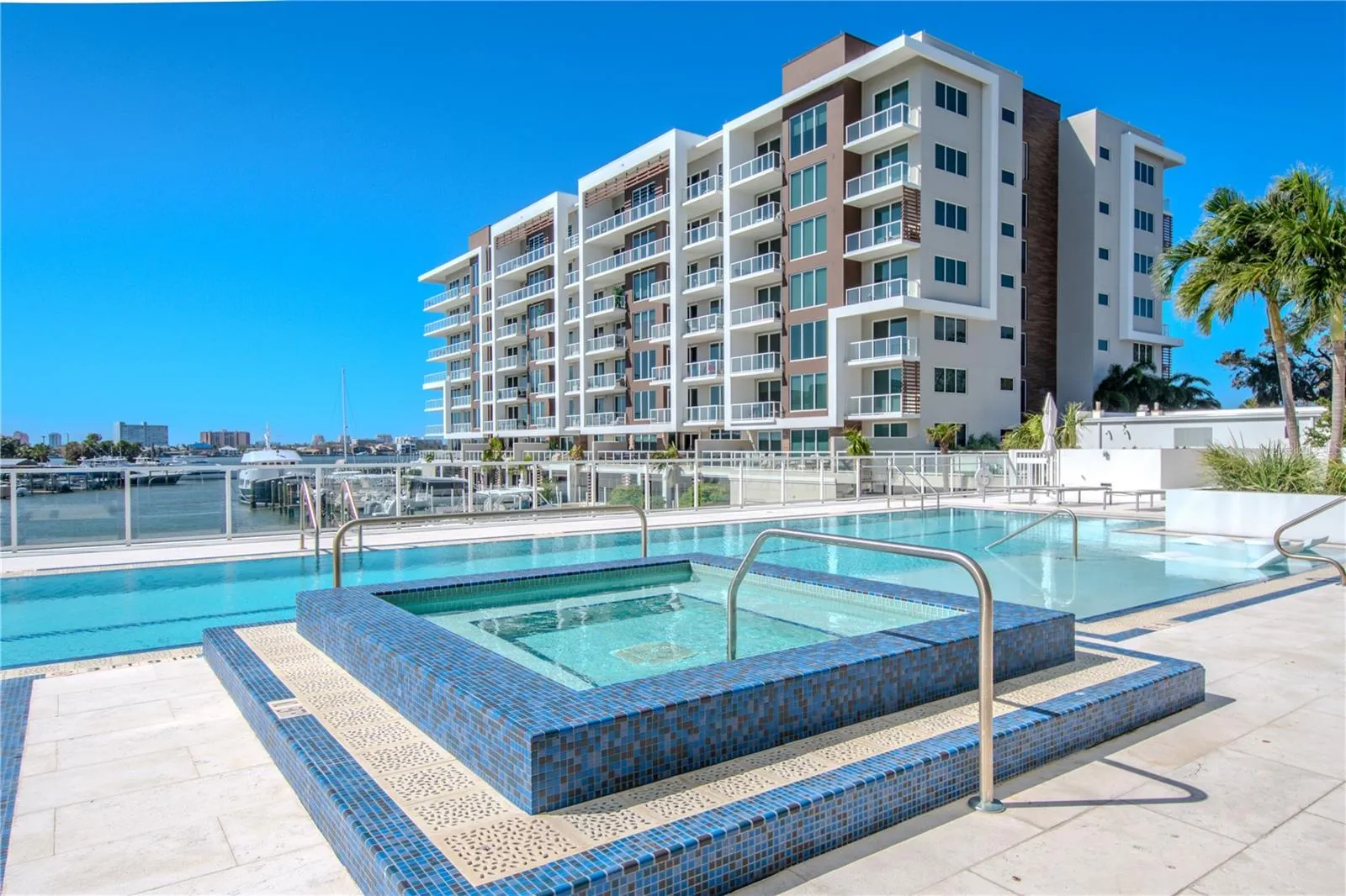 The resort-style amenities at Marina Bay 880 include a stunning 25-meter heated saltwater lap pool designed for both relaxation and fitness. Overlooking the Intracoastal Waterway, the pool features two expansive Baja shelves ideal for lounging in the water’s edge and soaking up the Florida sunshine. A raised spa with mosaic tile detailing provides the perfect spot to unwind while enjoying panoramic water and marina views. Surrounded by sleek glass railings and spacious deck seating, this waterfront oasis blends modern luxury with serene coastal living.
