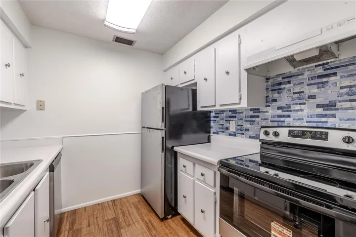 This  kitchen features an efficient layout and bright, clean design with white cabinetry and countertops creating a crisp backdrop
