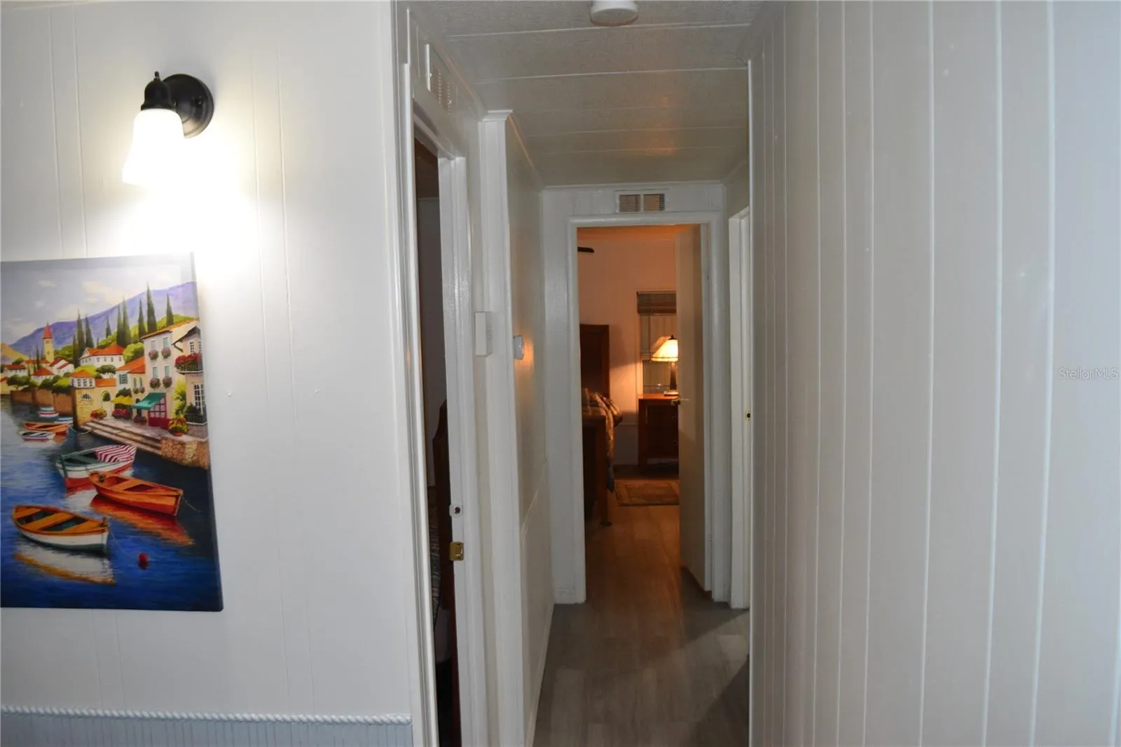 View from Living room to 2nd bedroom doorway on the left and primary bedroom down the hall