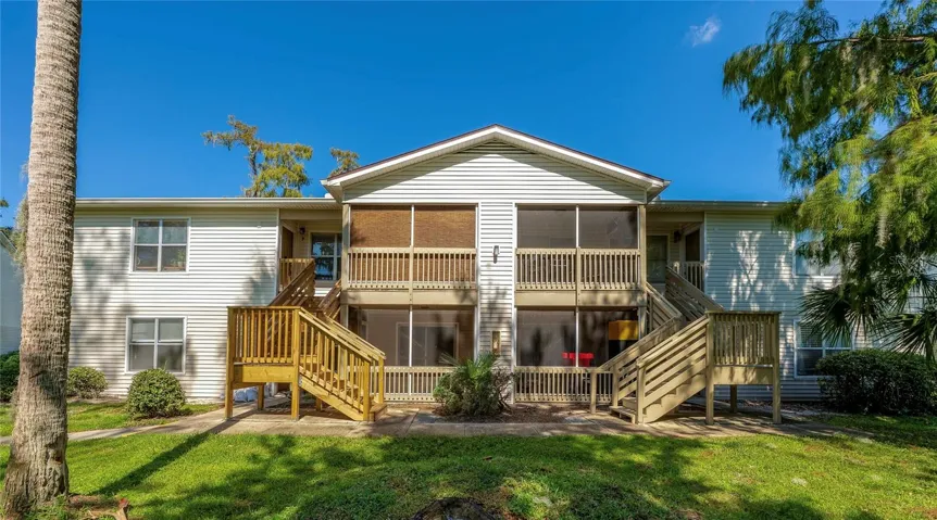Well-maintained exterior with light siding and updated wooden stairs, offering easy access to the unit and charming curb appeal.