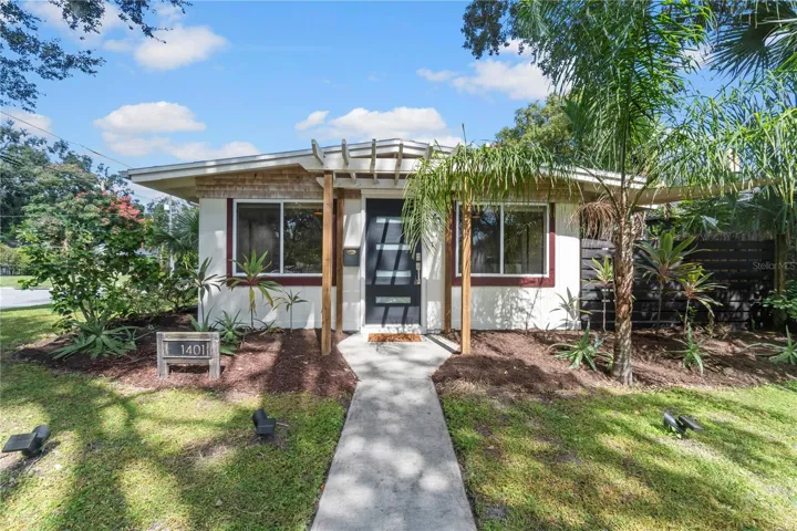 Exterior photo 3/1 cottage, corner lot with mature landscaping and paved walkway to the front door.