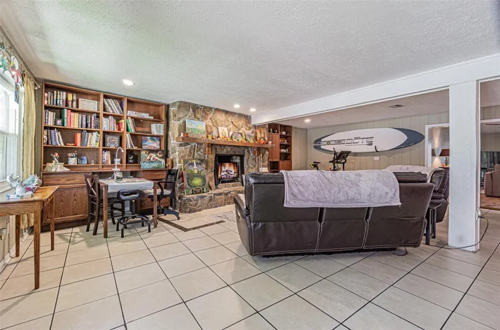Expansive family room with custom built-in shelving and a wood burning fireplace.