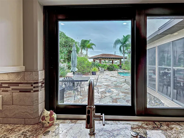 Look out the kitchen window to the pool area and the gazebo.