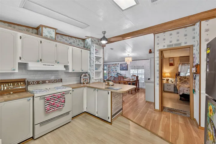 Kitchen view looking into hallway guest bedroom and dining area