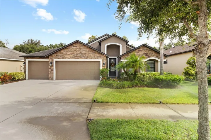 Day time reveals how lovely this 4 bedroom, 3 Car Ranch Home is with its stone accents and landscaped yard.