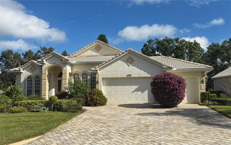 Front exterior with Paver driveway, 3 car garage or 2 car w golf cart garage, gutters, lush landscaping