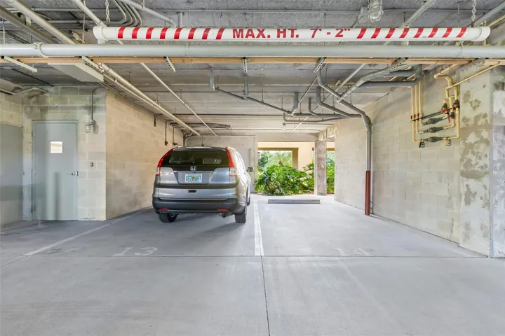 Two protected side-by-side covered parking spaces, the closest parking spaces next to the elevator lobby door on the left.