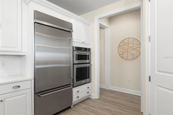 36" Kitchen-Aid refrigerator, dual ovens, pantry closet on the right.