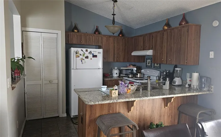 Kitchen with granite and passthrough to Living Room